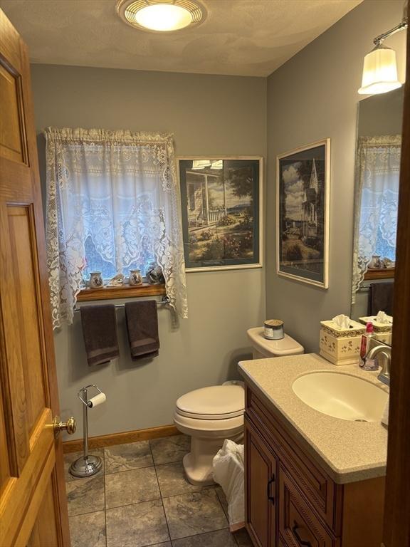 bathroom featuring vanity, baseboards, and toilet