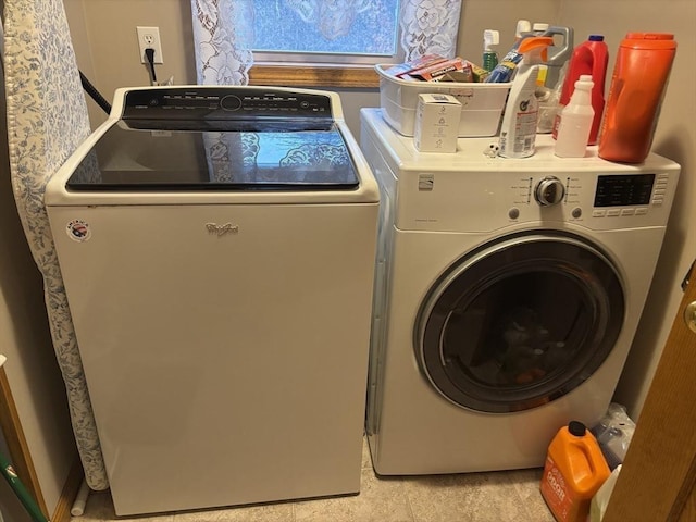laundry area with washer and clothes dryer and light tile patterned floors