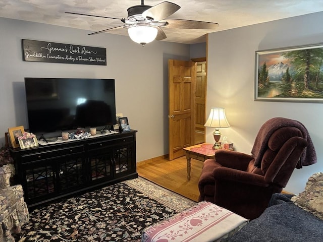living area featuring a ceiling fan and wood finished floors
