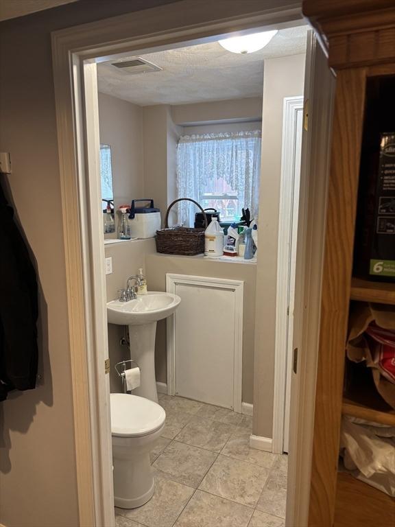 bathroom featuring tile patterned floors, toilet, and visible vents