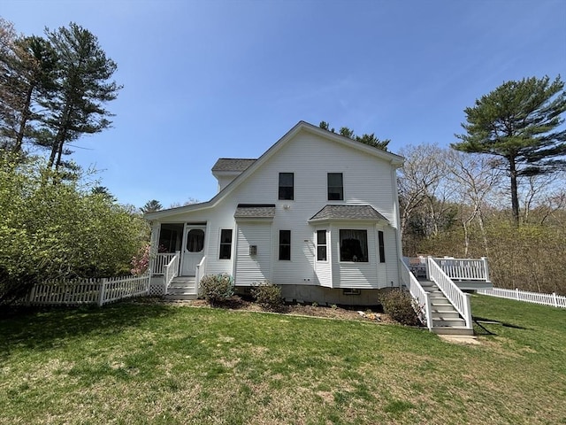 back of property with a lawn, fence, stairs, and a deck