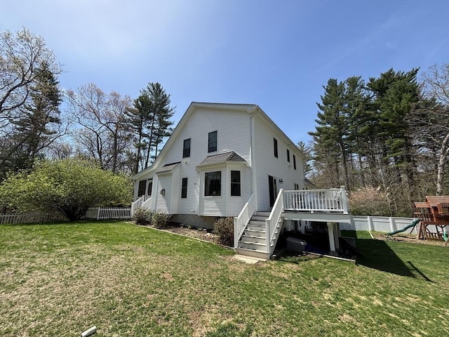 rear view of house featuring a wooden deck, stairway, a fenced backyard, a playground, and a yard