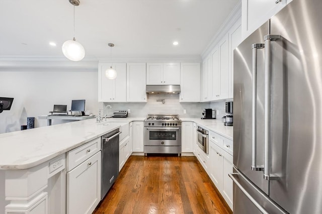 kitchen with pendant lighting, backsplash, white cabinets, premium appliances, and light stone countertops