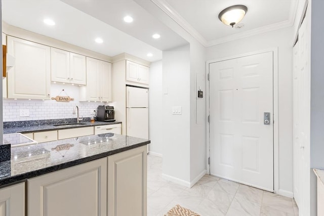 666 Main St Unit 206, Winchester, MA 01890 - kitchen with a sink, freestanding refrigerator, ornamental molding, baseboards, and dark stone counters