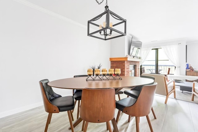 666 Main St Unit 206, Winchester, MA 01890 - dining area featuring a chandelier, crown molding, light wood-style flooring, and baseboards
