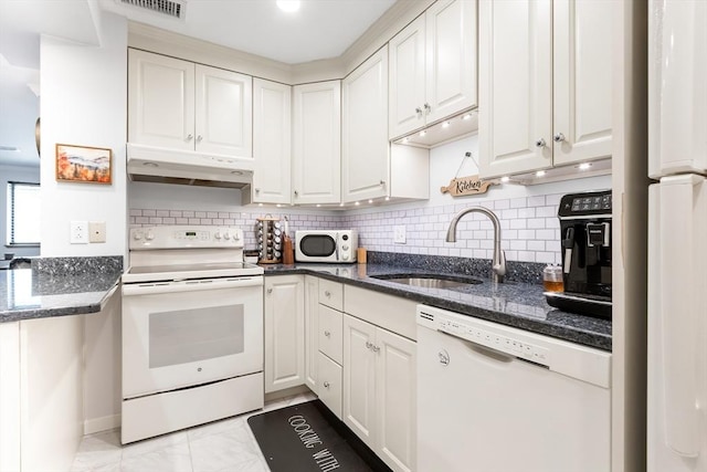 666 Main St Unit 206, Winchester, MA 01890 - kitchen with white appliances, under cabinet range hood, a sink, white cabinets, and dark stone countertops