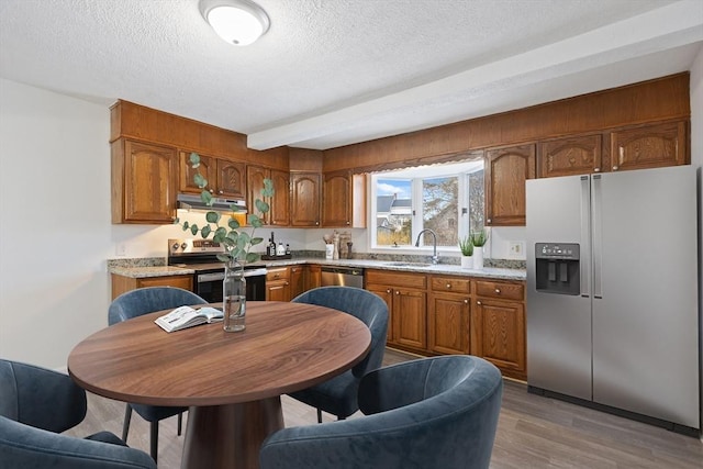 kitchen featuring appliances with stainless steel finishes, sink, dark wood-type flooring, and a textured ceiling