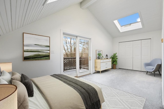 bedroom with vaulted ceiling with skylight, light carpet, access to exterior, and a closet