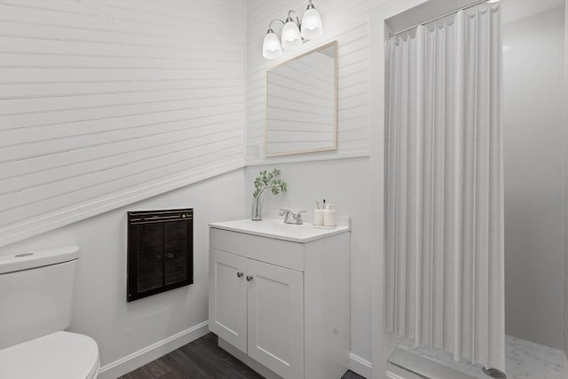 bathroom with vanity, wood-type flooring, heating unit, and toilet