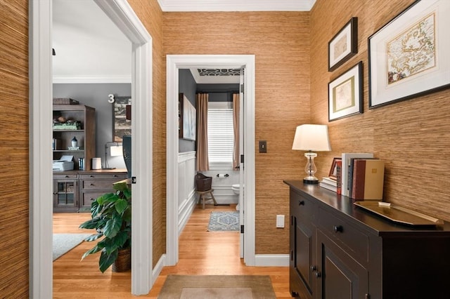 corridor with wainscoting and light wood-style flooring