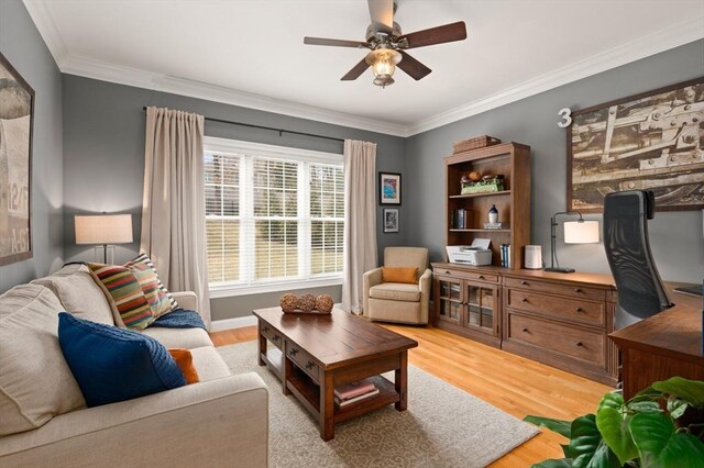 living area with wood finished floors, a ceiling fan, and ornamental molding