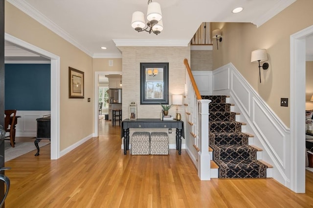 stairs featuring a decorative wall, wood finished floors, wainscoting, and ornamental molding