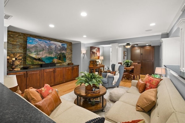 living area featuring visible vents, ornate columns, recessed lighting, crown molding, and light wood-type flooring