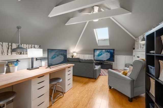 office featuring lofted ceiling with skylight, light wood-style floors, and ceiling fan