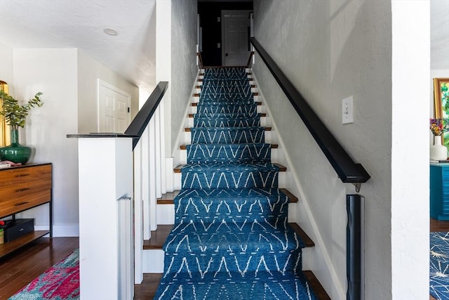 stairway featuring baseboards and wood finished floors