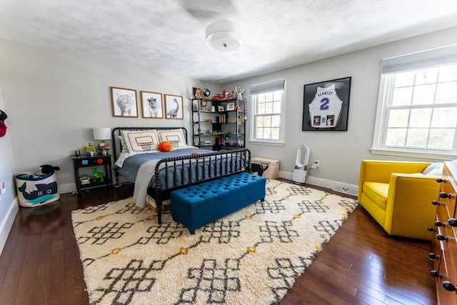 bedroom featuring baseboards, a textured ceiling, visible vents, and dark wood-style flooring