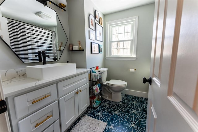 full bath featuring toilet, baseboards, and vanity