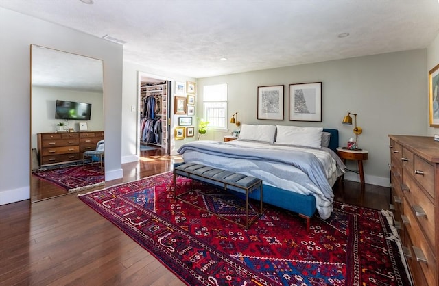 bedroom with dark wood-style flooring, a closet, and baseboards