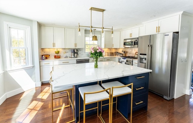 kitchen featuring a kitchen island, white cabinetry, hanging light fixtures, and high quality appliances