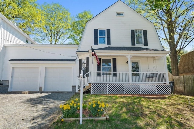 dutch colonial featuring covered porch, a garage, fence, gravel driveway, and a gambrel roof