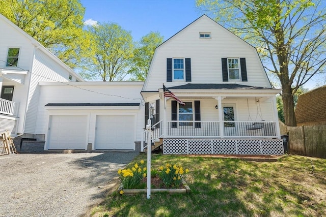 dutch colonial with covered porch, a garage, fence, and a gambrel roof