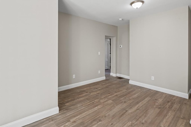 empty room with baseboards and wood finished floors