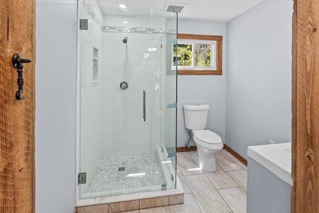 full bathroom featuring baseboards, a stall shower, and toilet