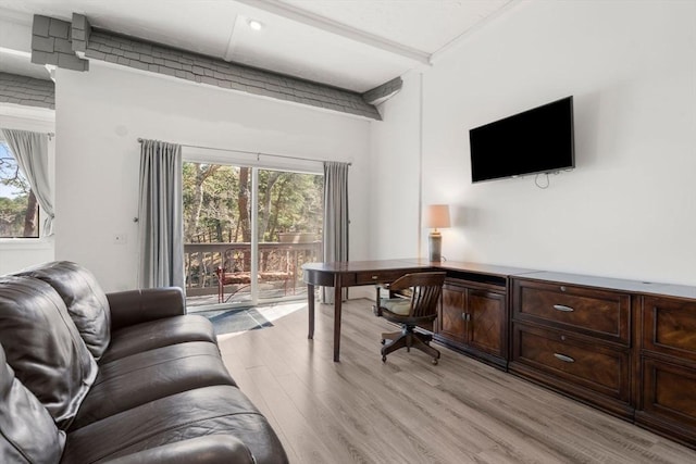office area with light wood-style flooring and beamed ceiling