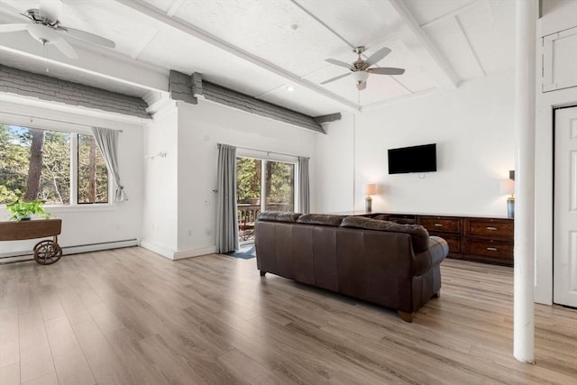 living area featuring ceiling fan, beamed ceiling, plenty of natural light, and light wood-style flooring