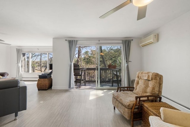 sitting room with ceiling fan, an AC wall unit, wood finished floors, and baseboard heating