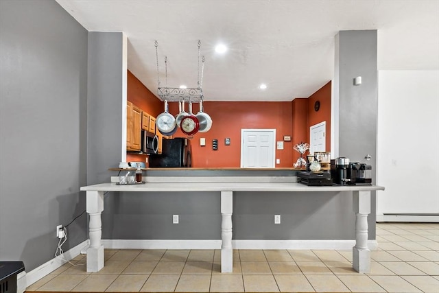 1185 Read St, Somerset, MA 02726 - kitchen with black fridge, stainless steel microwave, baseboard heating, a kitchen bar, and a peninsula