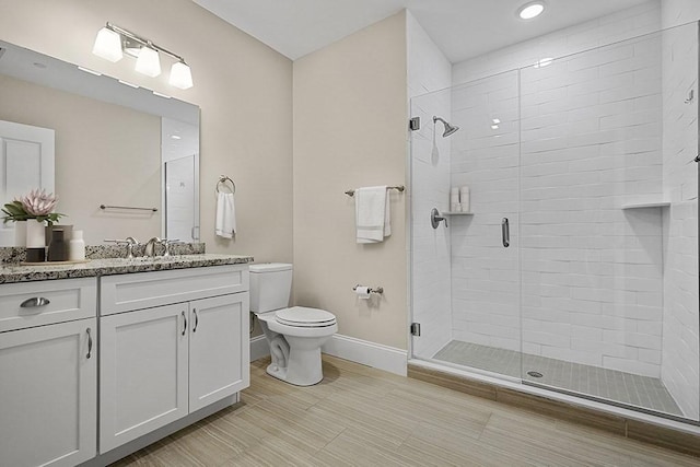 full bath featuring recessed lighting, toilet, vanity, baseboards, and a stall shower