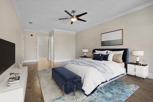 bedroom featuring wood finished floors, crown molding, visible vents, and baseboards