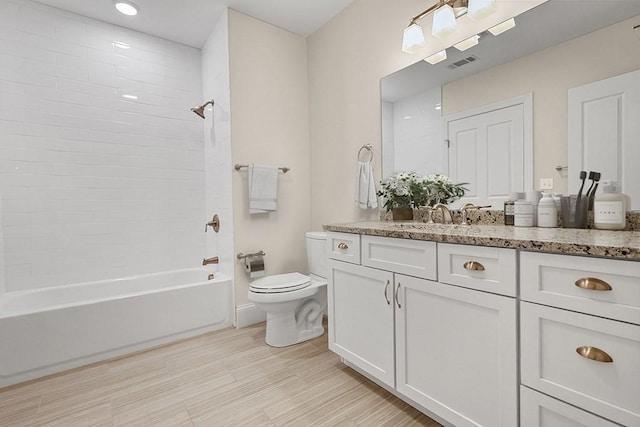 bathroom with washtub / shower combination, visible vents, toilet, and vanity