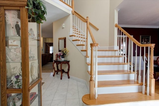 stairway with baseboards and crown molding