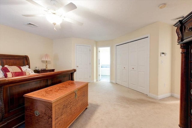 bedroom with visible vents, a closet, baseboards, light colored carpet, and ceiling fan