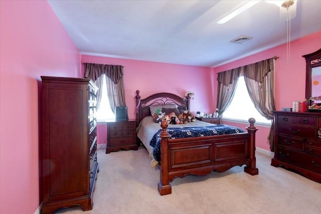 bedroom featuring baseboards, visible vents, and light carpet