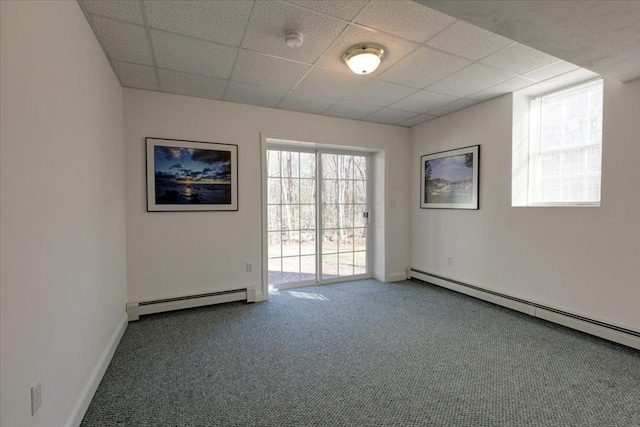 unfurnished room featuring baseboard heating, carpet flooring, a paneled ceiling, and baseboards