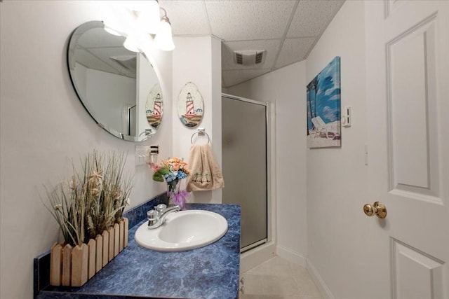 full bathroom featuring a drop ceiling, visible vents, a stall shower, and vanity