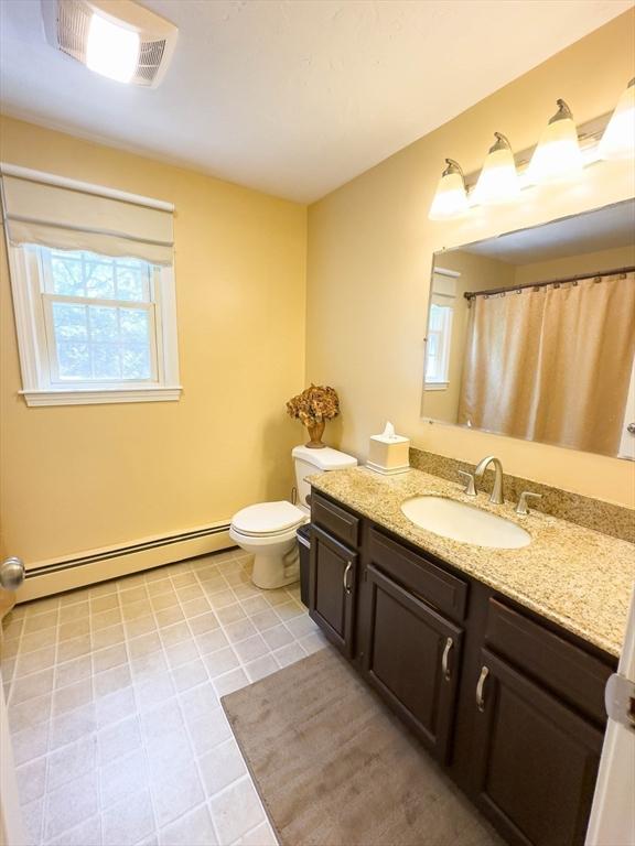93 Mccracken Rd, Millbury, MA 01527 - bathroom featuring a baseboard radiator, vanity, toilet, tile patterned flooring, and curtained shower