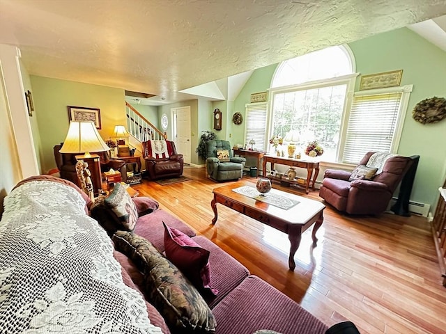 93 Mccracken Rd, Millbury, MA 01527 - living area featuring wood finished floors, stairs, a baseboard heating unit, baseboards, and vaulted ceiling