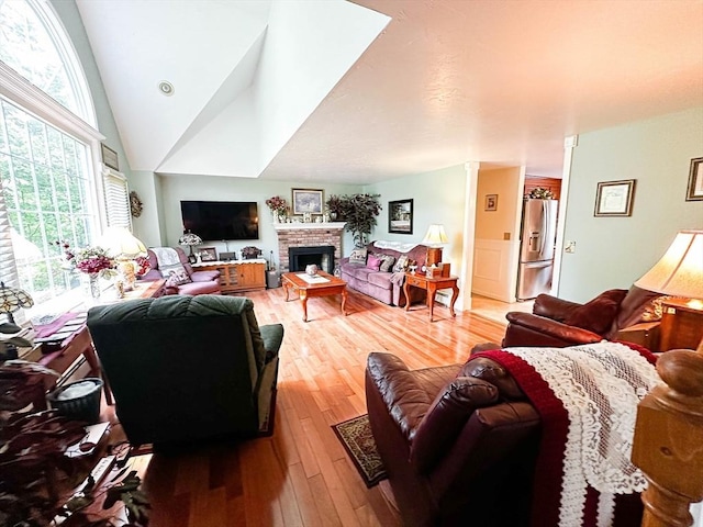 93 Mccracken Rd, Millbury, MA 01527 - living area featuring light wood-style flooring, a brick fireplace, and vaulted ceiling