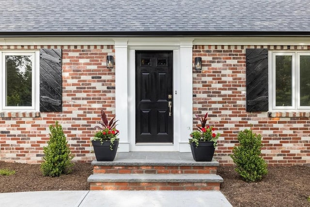 47 Jacob St, Seekonk, MA 02769 - view of exterior entry with a shingled roof and brick siding