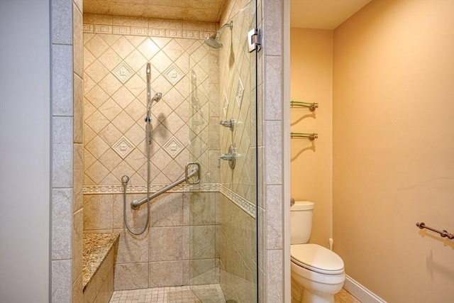 bathroom featuring toilet and a shower with shower door