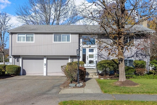 bi-level home with driveway and an attached garage