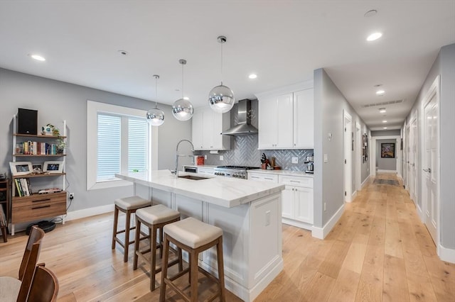 510 Dorchester Ave Unit 2R, Boston, MA 02127 - kitchen with wall chimney exhaust hood, light wood finished floors, a sink, baseboards, and white cabinetry