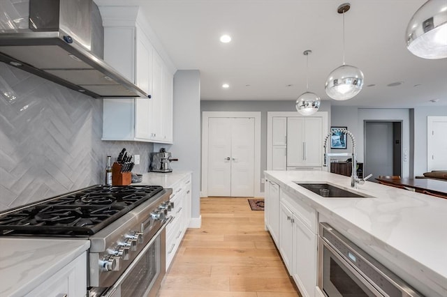510 Dorchester Ave Unit 2R, Boston, MA 02127 - kitchen with wall chimney range hood, stainless steel appliances, a sink, recessed lighting, and white cabinets
