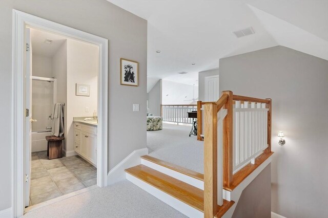 stairs with lofted ceiling, carpet flooring, visible vents, and baseboards