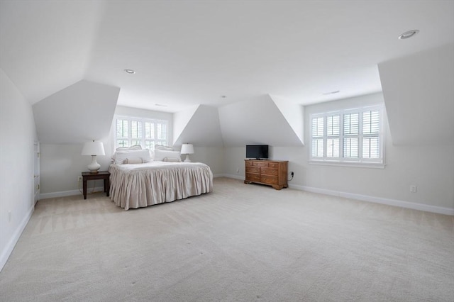 bedroom featuring lofted ceiling, baseboards, and carpet floors
