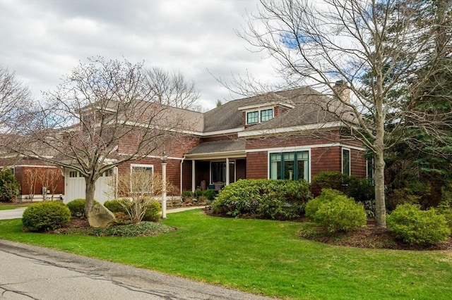 view of front of home with a chimney and a front yard